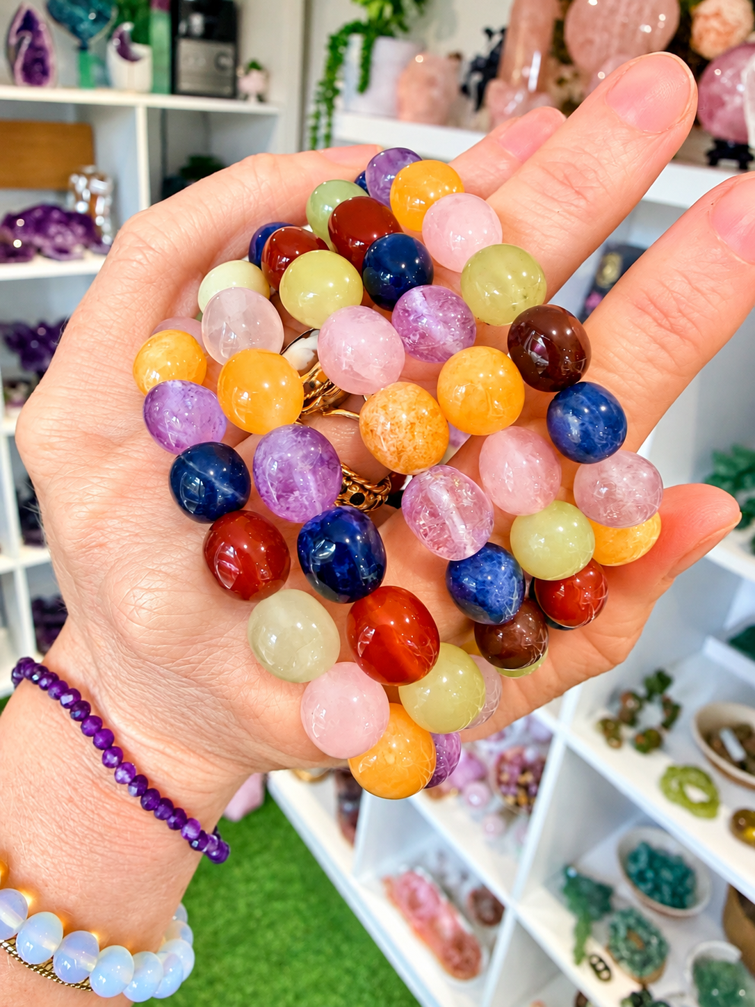 Close up of colourful mixed gemstone chakra bracelet beads held in hand 